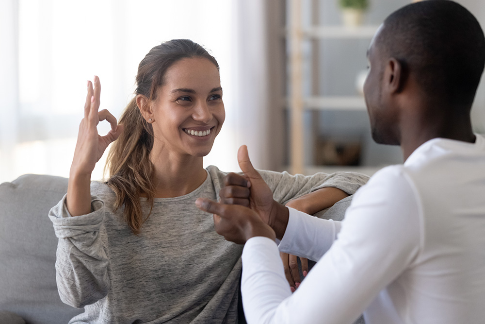 Two adults communicating through sign language