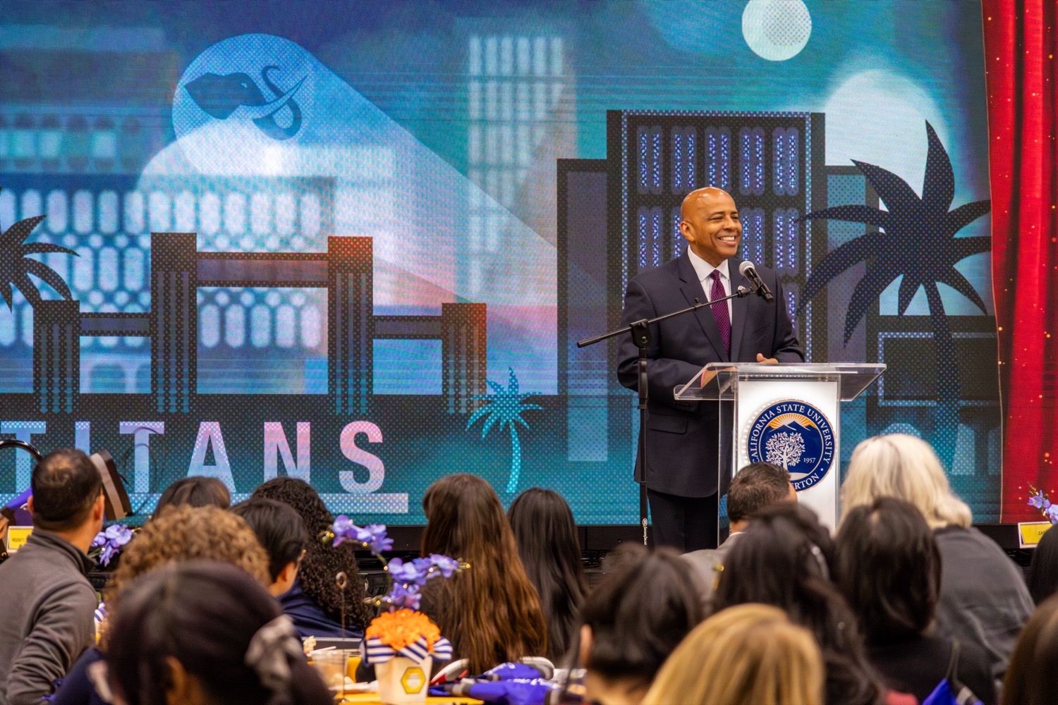 president Rochon on stage befind a podium in front of a large audience