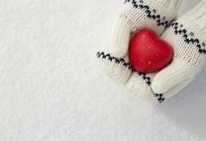 red heart toy held by two hands in white gloves 