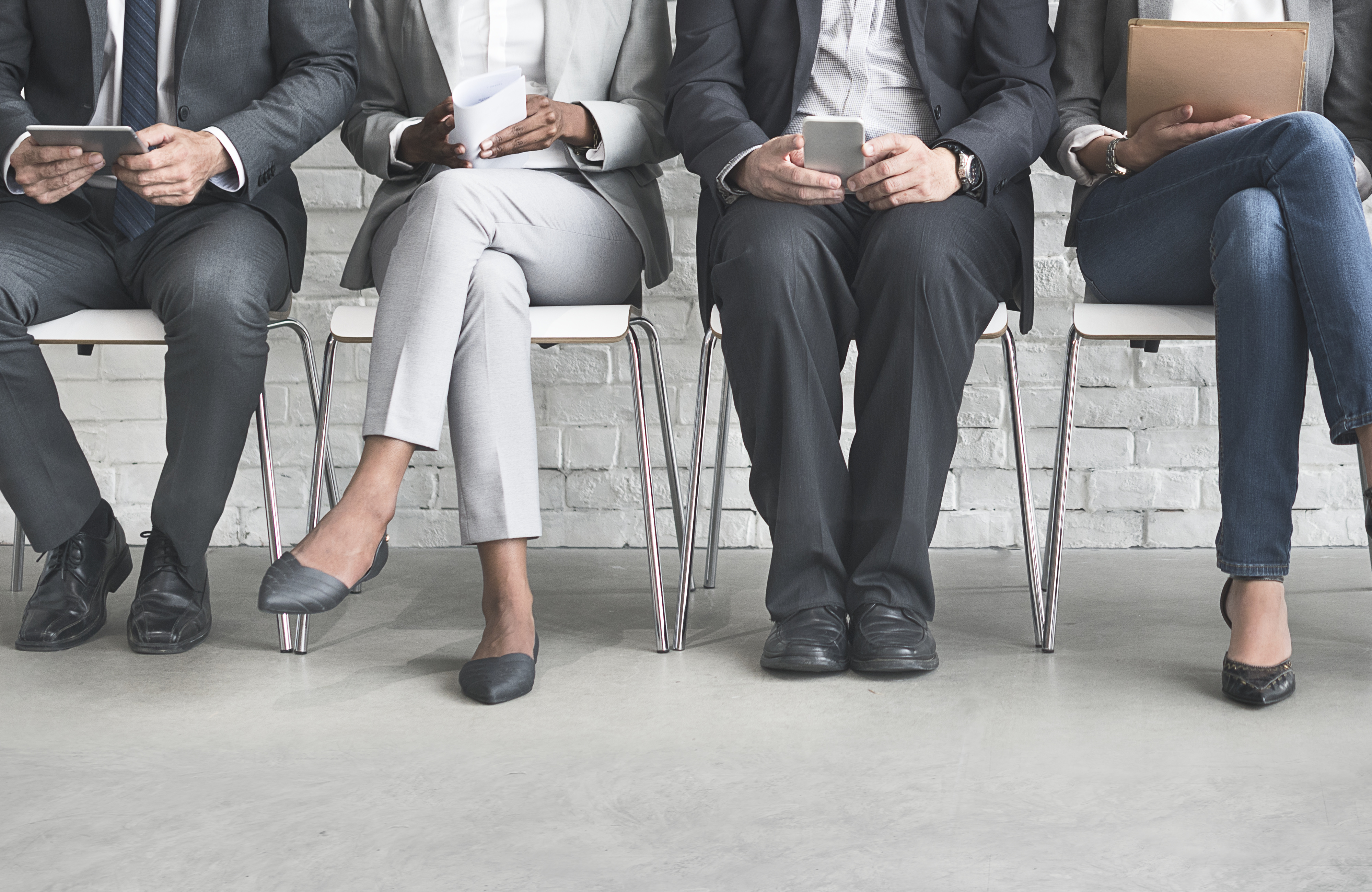 4 professionally dressed people sitting next to each other