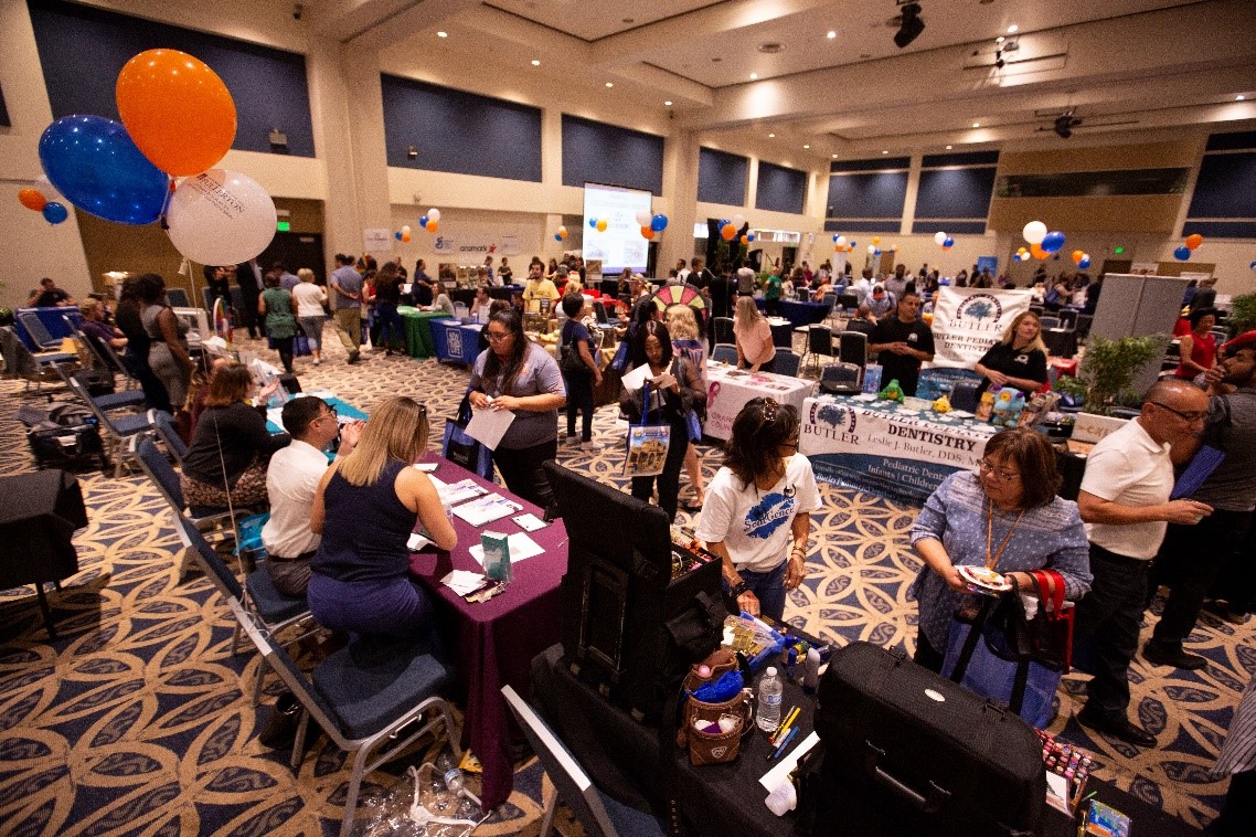 an event room full of people with many table set up for networking