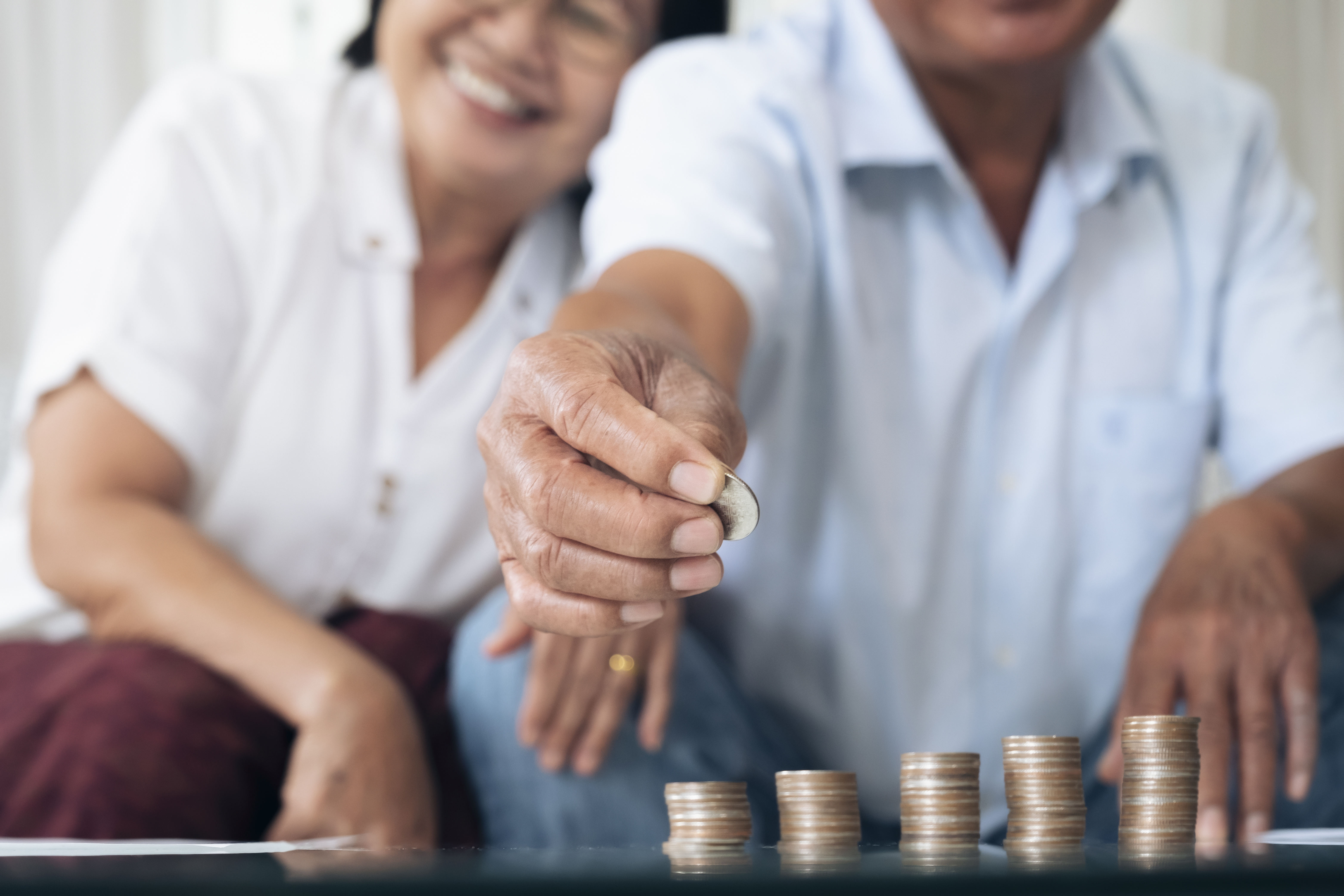 a couple sitting together with the man reaching out holding a coin