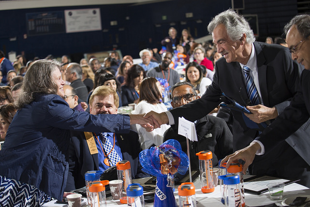 Employees shake hands before accepting award at UAP